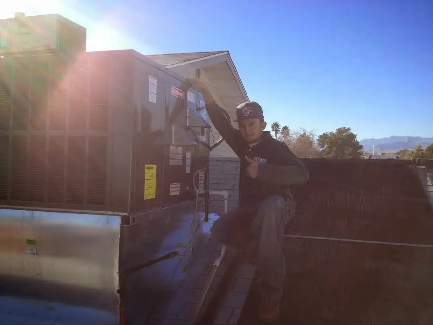 HVAC technician performing AC Tune-Up on a rooftop unit in Waterford